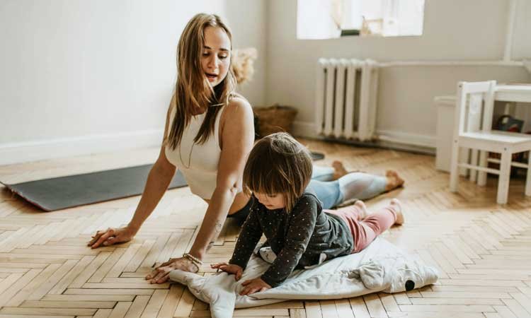 Kid doing yoga with his mother